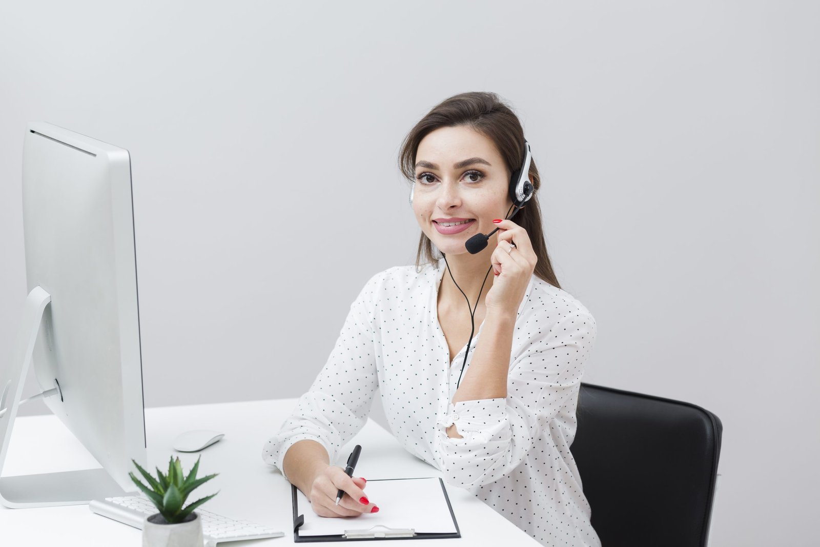 front-view-smiley-woman-posing-with-headset-desk-scaled
